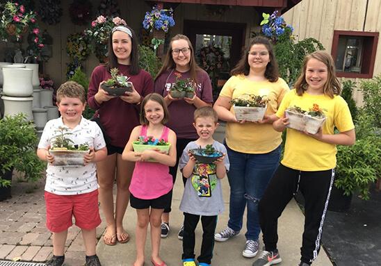 Talbot county 4 H ers hold up the plants they potted in 4 H plants class