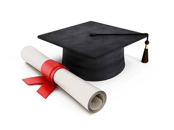  A black graduation cap with a tassel next to a rolled diploma tied with a red ribbon.