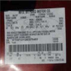 Close-up of a manufacturer information label affixed to a maroon vehicle door frame. The sticker shows printed black text on a white background with details such as “MFD. BY FORD MOTOR CO.,” a production date of 06/07, gross vehicle weight ratings, axle ratings, tire and rim specifications, cold tire pressure values, a VIN number, and barcodes. The label is slightly angled and mounted on painted metal.