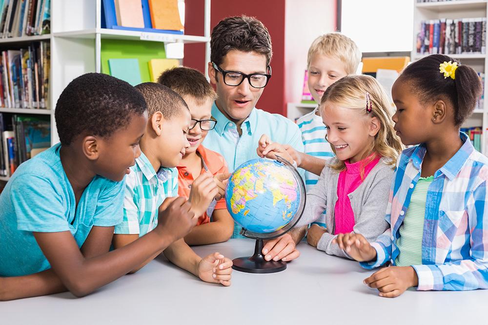 Picture of Teacher and kids looking at globe.