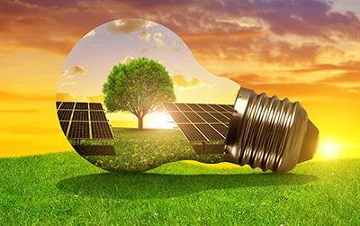 Solar energy panels in light bulb at sunset. The concept of sustainable resources. 