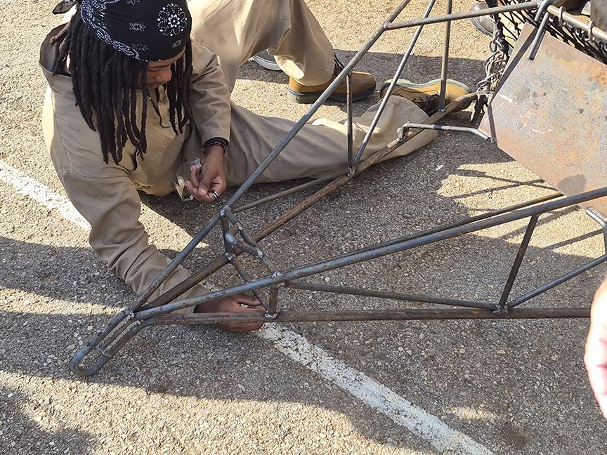 A North Point High CTE welding student examines the welds on an aquaculture dredge. 